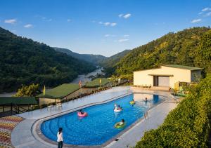 a resort swimming pool with people in the water at HR The nature resort in Birbhaddar +13 photos
