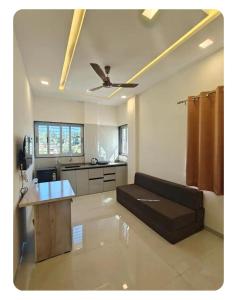 a living room with a couch and a ceiling fan at 46 Elite Enclave in Nashik