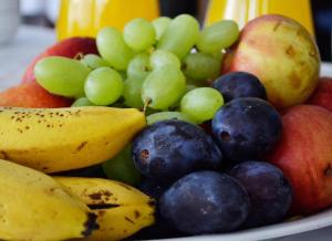 a bowl of fruit with grapes apples and bananas at Rooms Jagoda I Cozy Alpine Stay Near Bled in Blejska Dobrava +55 photos
