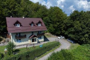 a house with a car parked next to a road at Casa Panorama Sovata in Sovata