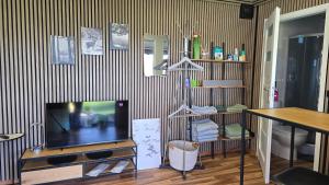 a living room with a tv and a table at Tiny House mit Fernblick in Verditz