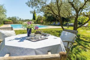 a table with a vase of flowers on it at la maison des Olivettes in Uzès