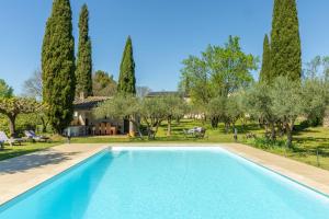 a swimming pool in a yard with trees at la maison des Olivettes in Uzès