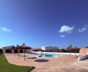 a swimming pool with umbrellas on a patio at La Guapa in Cala en Porter