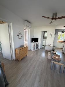 a living room with white walls and wooden floors at La Guapa in Cala en Porter