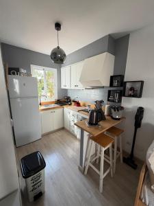 a kitchen with a white refrigerator and a table at La Guapa in Cala en Porter