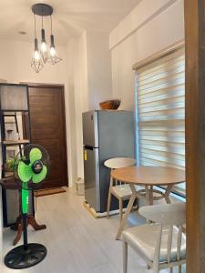 a kitchen with a table and a refrigerator at Villa El Marie in Bacnotan