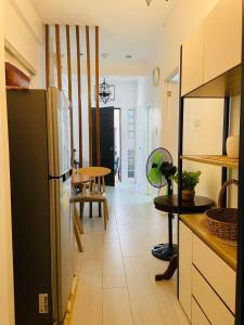 a kitchen with a black refrigerator and a table at Villa El Marie in Bacnotan