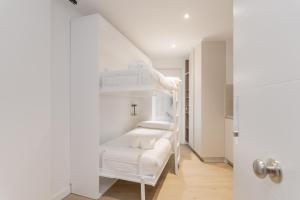 a room with white bunk beds in a white room at Pension Txapitela in Pamplona +40 photos