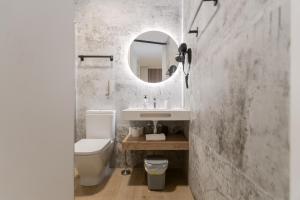 a bathroom with a sink and a toilet and a mirror at Pension Txapitela in Pamplona
