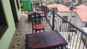 a balcony with chairs and tables on a balcony at Rupli homestay in Joshīmath