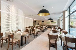 a restaurant with tables and chairs in a room at Parkhotel Lingen in Lingen