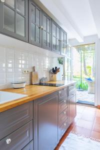 a kitchen with gray cabinets and a wooden counter top at la maison des Olivettes in Uzès