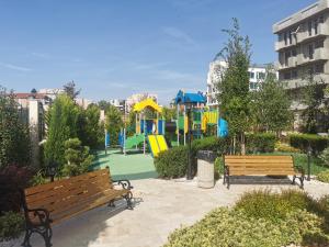 a park with two benches and a playground at Amber drop with a pool in Ravda