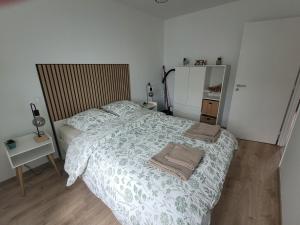 a bedroom with a bed and a table with a mirror at Appartement cosy in Commentry