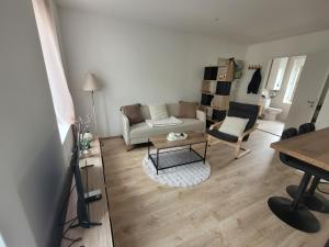a living room with a couch and a table at Appartement cosy in Commentry