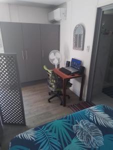 a bedroom with a desk with a laptop computer on it at Chez Teivama in Haapiti +24 photos