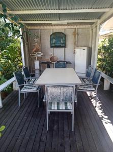 a white table and chairs on a wooden deck at Chez Teivama in Haapiti
