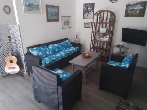 a living room with a couch and chairs and a table at Chez Teivama in Haapiti
