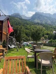 a picnic table and chairs with a view of mountains at Guesthouse Skender Selimaj in Valbonë