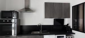 a kitchen with a sink and a microwave at studio chez amandine in Pernes-les-Fontaines
