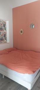 a bedroom with a bed with a red comforter at studio chez amandine in Pernes-les-Fontaines