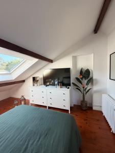 a bedroom with a bed and a dresser and a window at Chambre 24h Le Mans in Guécélard