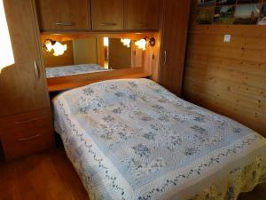 um pequeno quarto com uma cama e um espelho em Chalet Daria em Prémanon