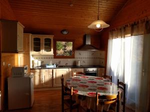 une cuisine avec une table et des placards blancs dans l'établissement Chalet Daria, à Prémanon