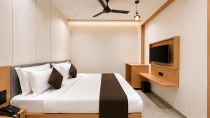 a hotel room with a bed and a television at Hotel Rushikesh inn Dwarka in Dwarka +16 photos