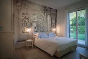 a bedroom with a bed and a large window at Arli Hotel Hideaway Punta Ala - Adults Only in Punta Ala