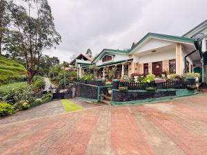 a house with a garden in front of it at Little England Grand Hotel in Nuwara Eliya