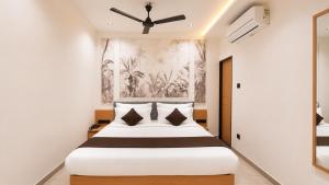 a bedroom with a large bed with a ceiling fan at Hotel Rushikesh inn Dwarka in Dwarka