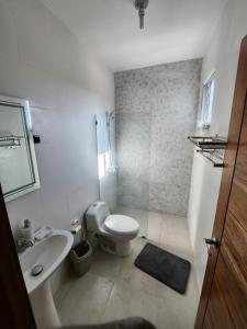 a white bathroom with a toilet and a sink at Charming home in Cancino +22 photos