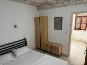 a bedroom with a bed and a wooden cabinet at Apartman Perast in Perast