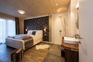 a bedroom with a bed and a shower and a sink at An der Kaburga in Telfes im Stubai
