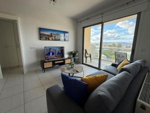 a living room with a couch and a large window at Queens Boutique Apartment 2BR in Ayios Dhometios