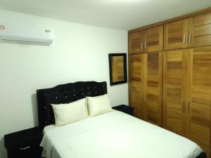 a bedroom with a bed and wooden cabinets at Charming home in Cancino