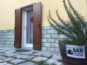uma porta com um sinal em frente a uma casa em B&B Valle Spluga Il Pertugio em Chiavenna