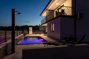 a villa with a swimming pool at night at Luxury-relax residence Muraj in Kornić