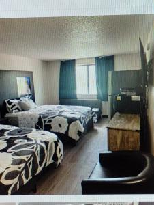 a hotel room with two beds and a chair at The suite in Rapid City