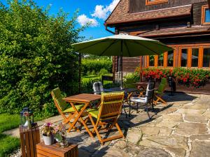 a patio with a table and chairs and an umbrella at Penzion V peřině in Trojanovice