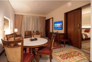 a living room with a table and a bedroom at Hunza Serena Hotel in Hunza Valley +17 photos