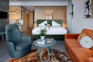 a hotel room with a bed and a couch at Das Traunsee - Das Hotel zum See 4 Stern Superior in Traunkirchen