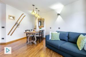 a living room with a blue couch and a table at Hostdomus - Clotes Dream Suite in Sauze d'Oulx