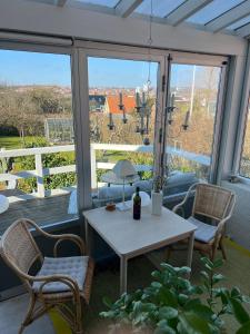 a table and chairs on a porch with a view at Charming sunroom with panorama view in Randers