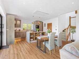 a kitchen and living room with a table and chairs at Brynor Lodge in Great Torrington +40 photos