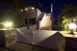 a white fence in front of a house with lights at Nuvolet Apartaments in Cala en Blanes
