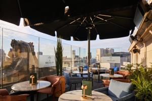 a restaurant with tables and chairs and an umbrella at The Rex - formerly Hotel Gotham in Manchester
