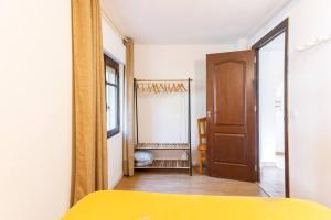 a bedroom with a yellow bed and a mirror at Estudio Las Rotas in Denia